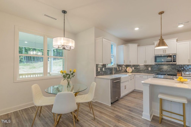 kitchen with tasteful backsplash, light countertops, and appliances with stainless steel finishes