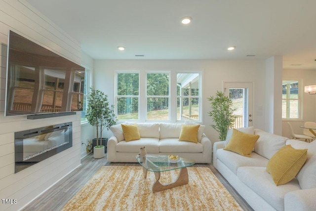 living area featuring recessed lighting, plenty of natural light, and wood finished floors