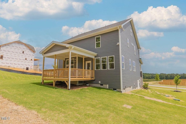 back of house with crawl space, a deck, and a lawn