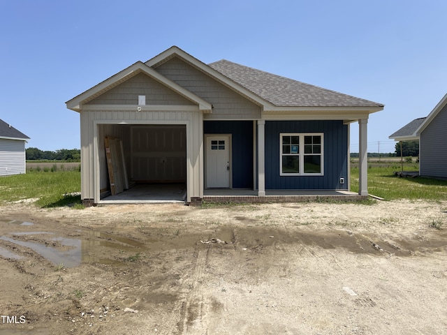 506 S Vance St, Fremont, NC 27830 - view of front facade with board and batten siding, roof with shingles, covered porch, and a garage