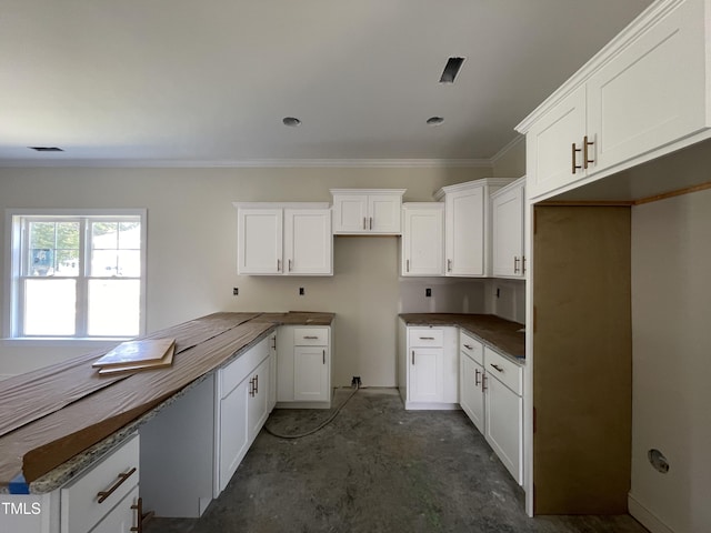 506 S Vance St, Fremont, NC 27830 - kitchen featuring concrete floors, crown molding, and white cabinets