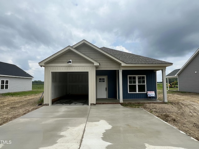 506 S Vance St, Fremont, NC 27830 - view of front of home with a porch, driveway, board and batten siding, a shingled roof, and a garage