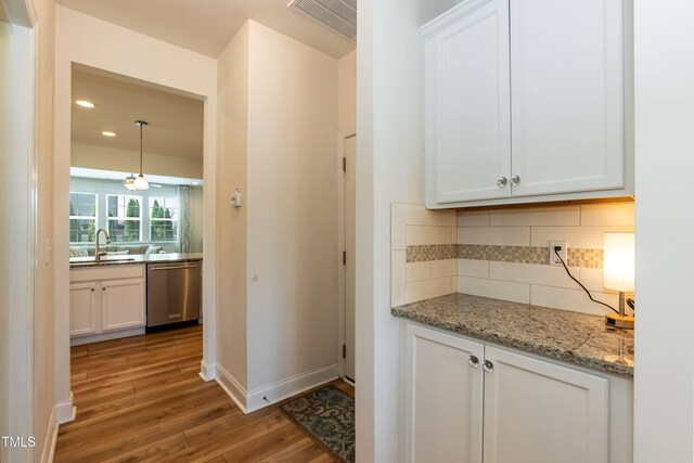3536 Greenville Loop Rd, Wake Forest, NC 27587 - kitchen with dishwasher, a sink, wood finished floors, white cabinetry, and recessed lighting