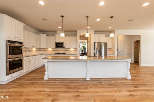 3536 Greenville Loop Rd, Wake Forest, NC 27587 - kitchen featuring stainless steel appliances, white cabinetry, a sink, a spacious island, and tasteful backsplash