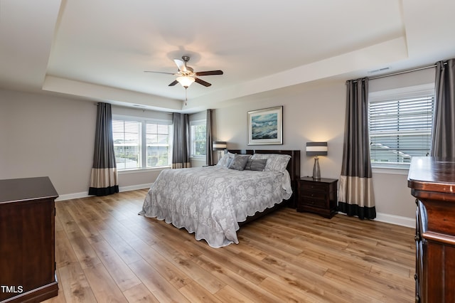 3536 Greenville Loop Rd, Wake Forest, NC 27587 - bedroom with a tray ceiling, baseboards, light wood-style flooring, and a ceiling fan