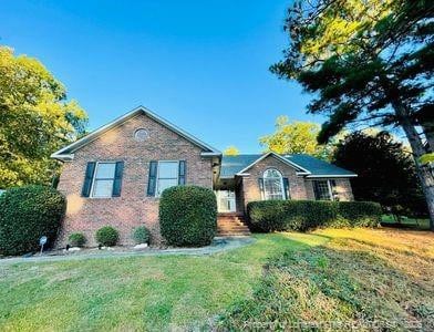 ranch-style house featuring a front lawn and brick siding