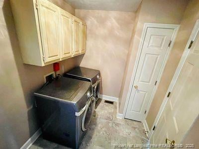 laundry room with cabinet space, washer and dryer, and baseboards
