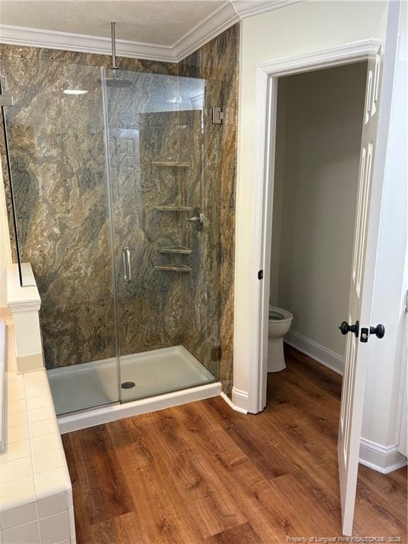 6976 Kings Lynn Loop, Fayetteville, NC 28304 - full bath featuring a shower stall, crown molding, wood finished floors, toilet, and baseboards