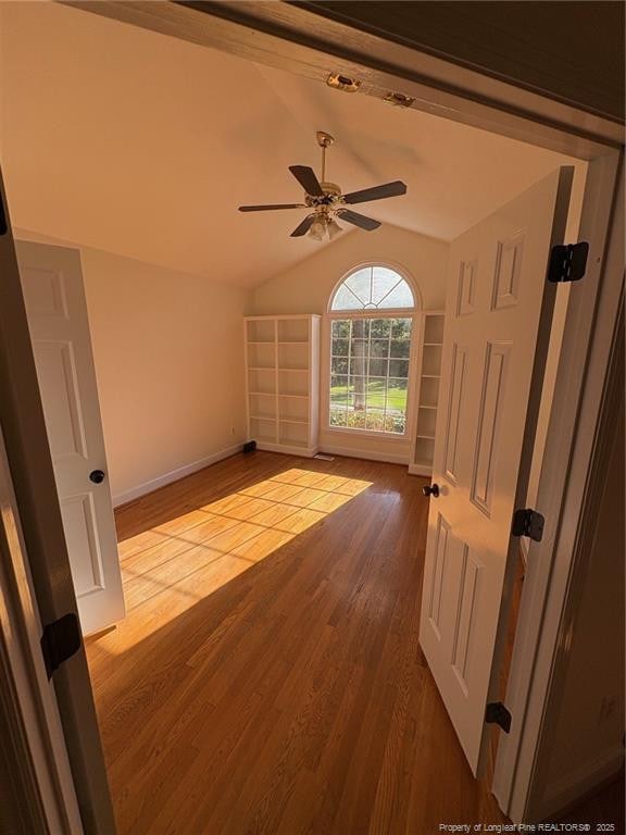 6976 Kings Lynn Loop, Fayetteville, NC 28304 - spare room featuring wood finished floors, ceiling fan, lofted ceiling, and baseboards