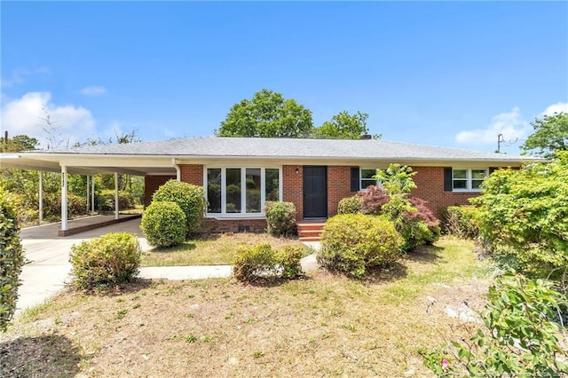 ranch-style home with concrete driveway, a carport, and brick siding