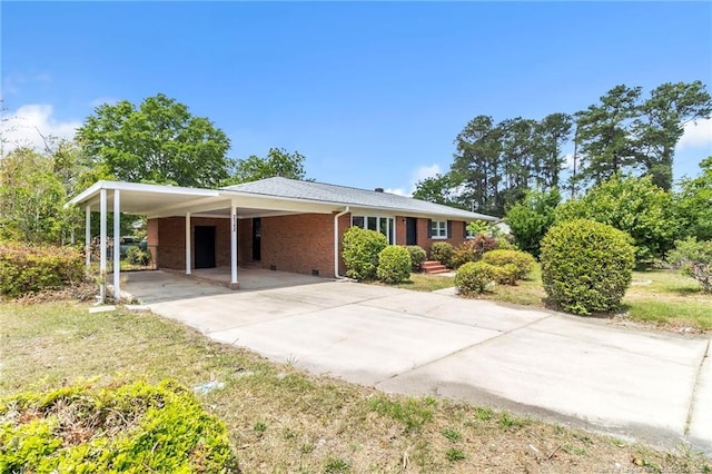 ranch-style home with concrete driveway, brick siding, and a carport