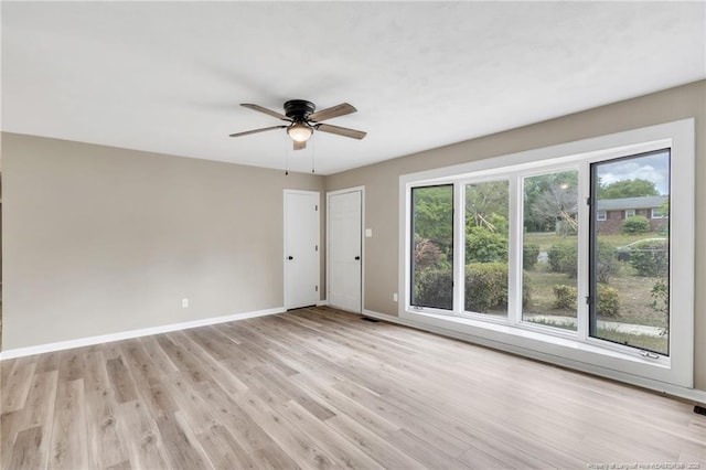 spare room featuring baseboards, ceiling fan, and light wood-type flooring