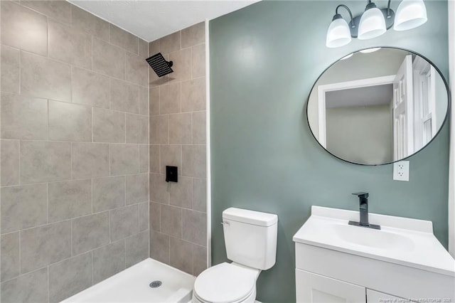 full bathroom featuring vanity, toilet, and a tile shower