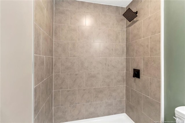 full bath featuring toilet and a tile shower