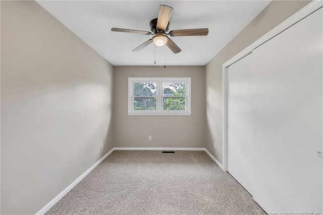 carpeted empty room featuring ceiling fan, baseboards, and visible vents