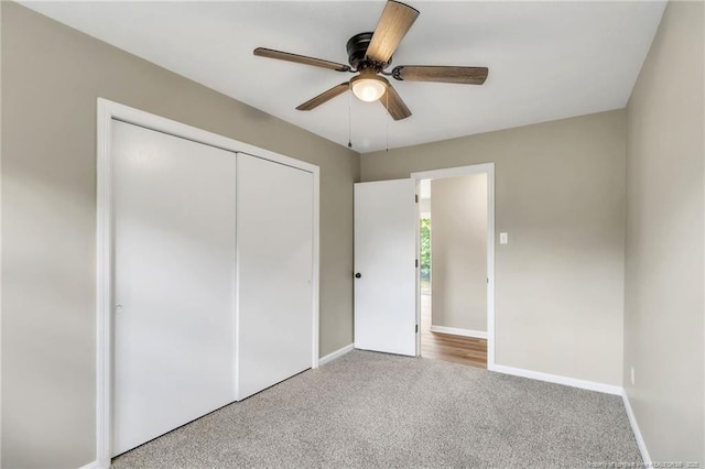 unfurnished bedroom with carpet flooring, a closet, baseboards, and ceiling fan