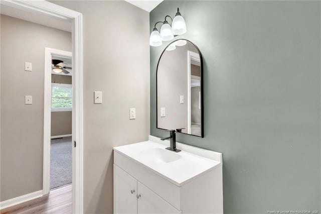 bathroom with vanity, baseboards, a ceiling fan, and wood finished floors