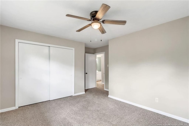 unfurnished bedroom featuring ceiling fan, carpet, baseboards, and a closet