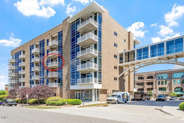 view of apartment building / complex with uncovered parking