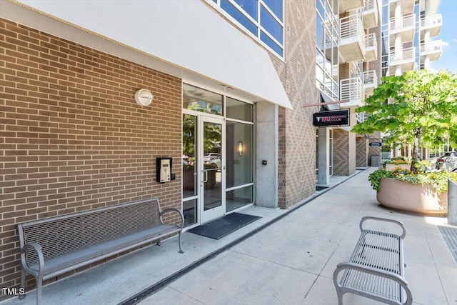 doorway to property featuring brick siding