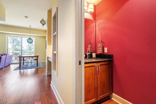 bathroom featuring wood finished floors, baseboards, and vanity