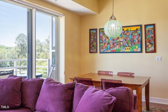 dining room featuring plenty of natural light, baseboards, wood finished floors, and a chandelier