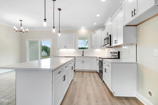 157 Gumtop Dr, Zebulon, NC 27597 - kitchen with appliances with stainless steel finishes, light wood-style flooring, tasteful backsplash, healthy amount of natural light, and ornamental molding