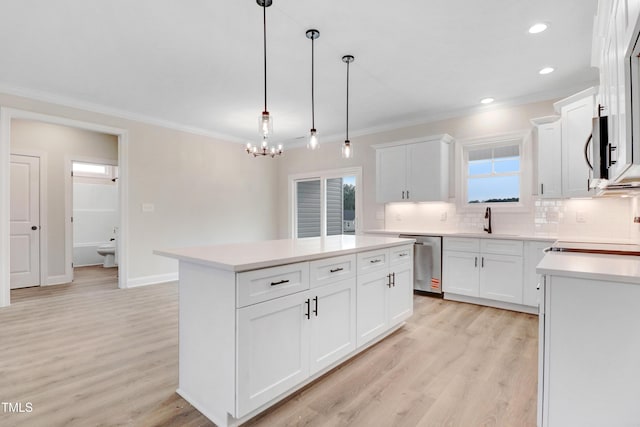 157 Gumtop Dr, Zebulon, NC 27597 - kitchen featuring stainless steel appliances, tasteful backsplash, ornamental molding, a kitchen island, and light wood-style flooring