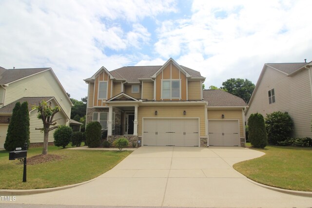 craftsman-style home with stone siding, driveway, a garage, and a front yard