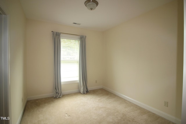 unfurnished room featuring light colored carpet and baseboards