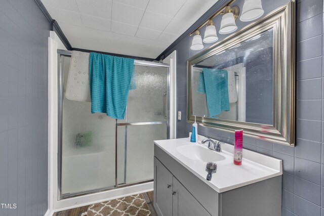 full bath featuring a stall shower, vanity, and crown molding