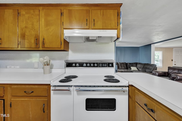 kitchen with white electric range oven, under cabinet range hood, light countertops, open floor plan, and brown cabinets