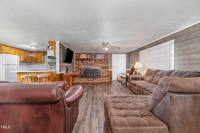 1169 Clayhole Rd, Dunn, NC 28334 - living area featuring dark wood-type flooring, a wood stove, ceiling fan, and wood walls
