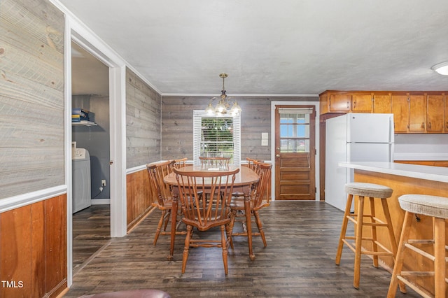 1169 Clayhole Rd, Dunn, NC 28334 - dining area featuring washer / dryer, wood walls, dark wood finished floors, ornamental molding, and a wainscoted wall