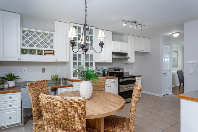 kitchen with range with two ovens, under cabinet range hood, a chandelier, and white cabinetry