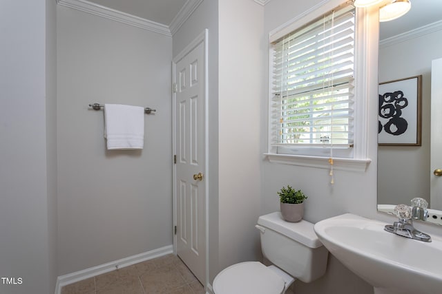 half bath featuring a sink, crown molding, toilet, baseboards, and tile patterned floors