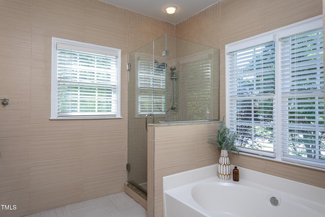 full bathroom featuring plenty of natural light, a shower stall, and a bath