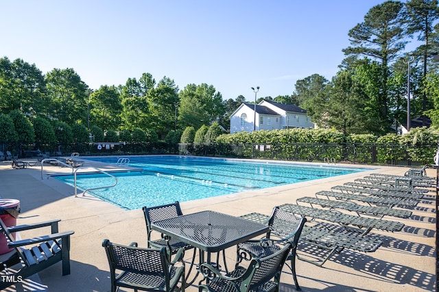 community pool featuring fence and a patio