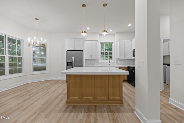 100 Citrus Pl, Cary, NC 27519 - kitchen with appliances with stainless steel finishes, light wood-style floors, a sink, white cabinetry, and a center island