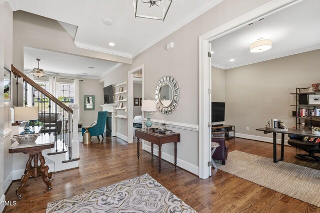 foyer entrance with crown molding, wood finished floors, stairway, baseboards, and a ceiling fan
