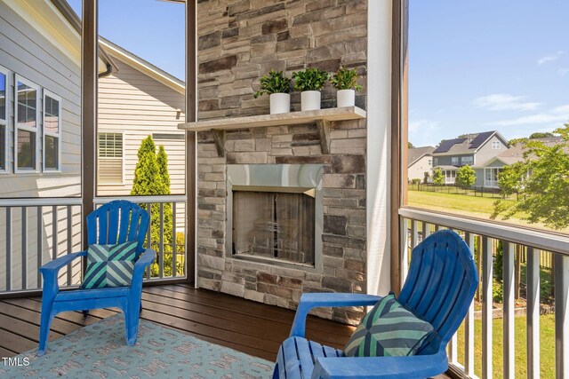 balcony with an outdoor stone fireplace