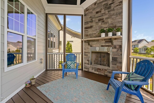 sunroom with an outdoor stone fireplace