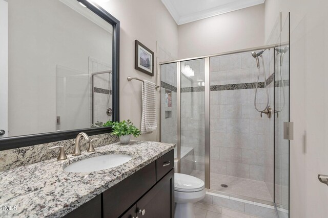 bathroom featuring a shower stall, ornamental molding, vanity, toilet, and tile patterned floors