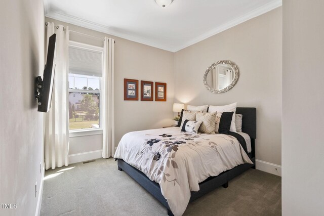 carpeted bedroom featuring crown molding and baseboards