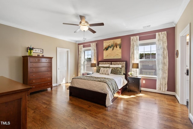 bedroom with wood finished floors, ornamental molding, baseboards, and ceiling fan