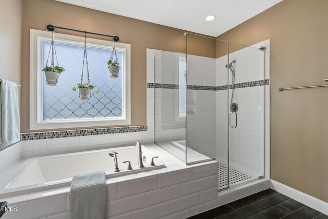 bathroom with baseboards, a shower stall, a garden tub, and recessed lighting
