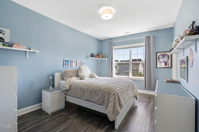 bedroom featuring baseboards and dark wood-style floors
