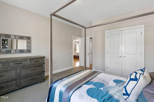 carpeted bedroom featuring a closet and baseboards