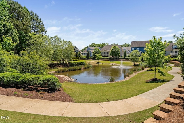 surrounding community featuring a water view and a lawn