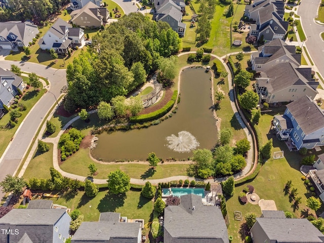 aerial view of property's location with nearby suburban area, a large body of water, and a pool area